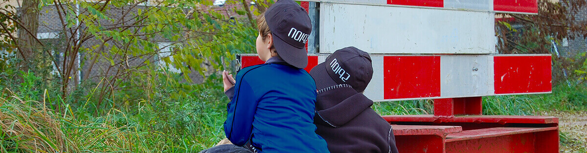 Twee jongens van 10 jaar zitten buiten verborgen tijdens hun spionnen kinderfeestje